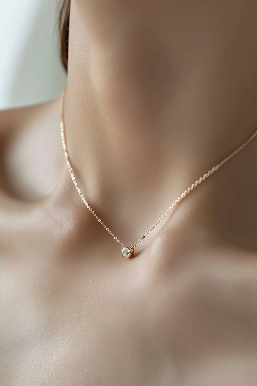 Minimalist gold necklace with a tiny round diamond, on a white skin neck against a white background, in a high resolution photography shot with crisp focus and hyper realistic detail, in the professional photograph.