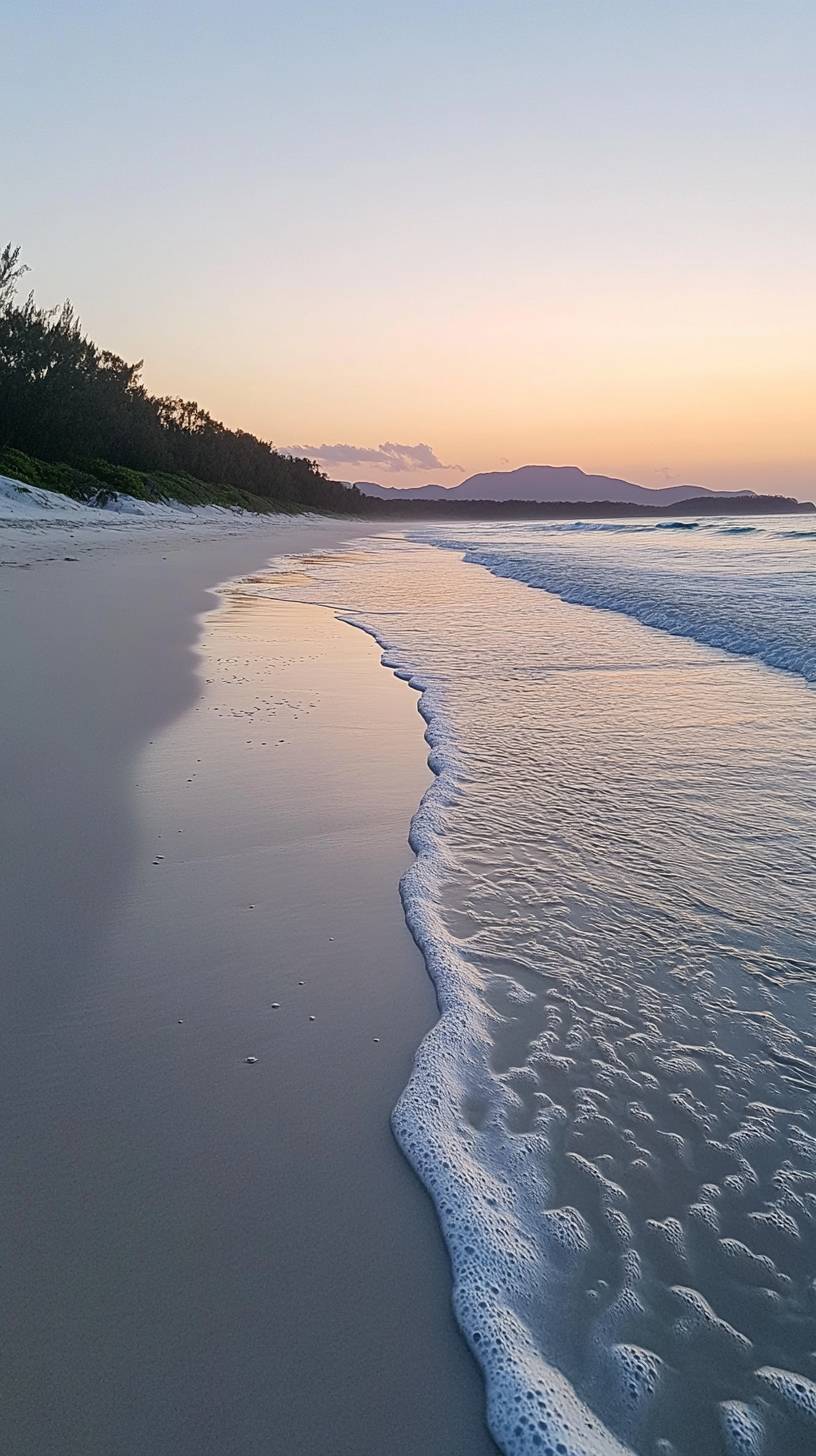 Playa de arena blanca al amanecer, con suaves olas y un cielo en tonos pastel que refleja la naturaleza pura.